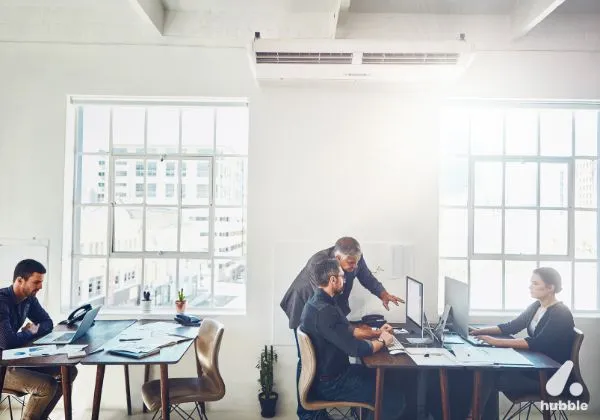 Modern office setting with employees collaborating, highlighting workplace motivation and employee recognition.