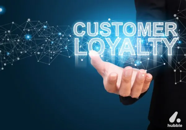 Hand holding a glowing "Customer Loyalty" text with digital network graphics, representing the impact of personalization on loyalty programs.