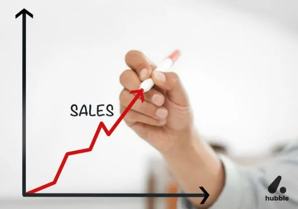 Hand drawing an upward sales growth chart with a red marker, symbolizing the impact of effective incentive programs on revenue.
