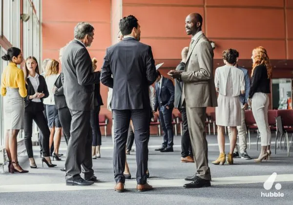 Professionals networking at a corporate event, representing experiential marketing and brand loyalty through engagement.