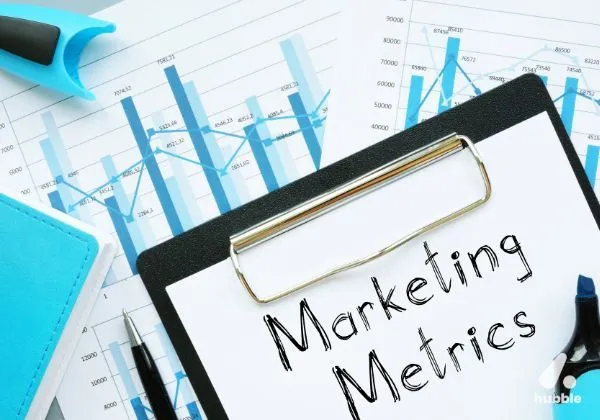 Clipboard with "Marketing Metrics" on it, placed over charts, representing experiential marketing measurement.