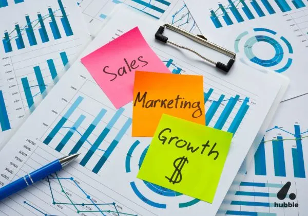 Sticky notes with "Sales," "Marketing," and "Growth" on charts, symbolizing behavioral nudges in marketing and sales