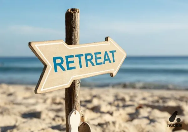 "RETREAT" sign on a beach, representing corporate retreats and investment value.