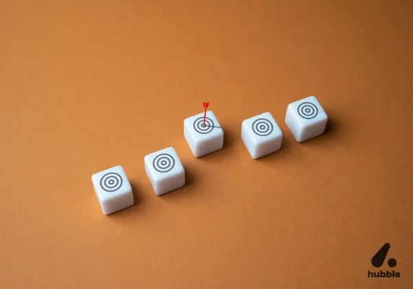 Five dice with target icons, one featuring a red arrow hitting the bullseye, symbolising overcoming goal achievement challenges.