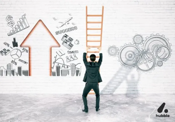 Businessman holding a ladder, preparing to climb towards a large upward arrow on a wall filled with success symbols like money, gears, team, and growth charts.